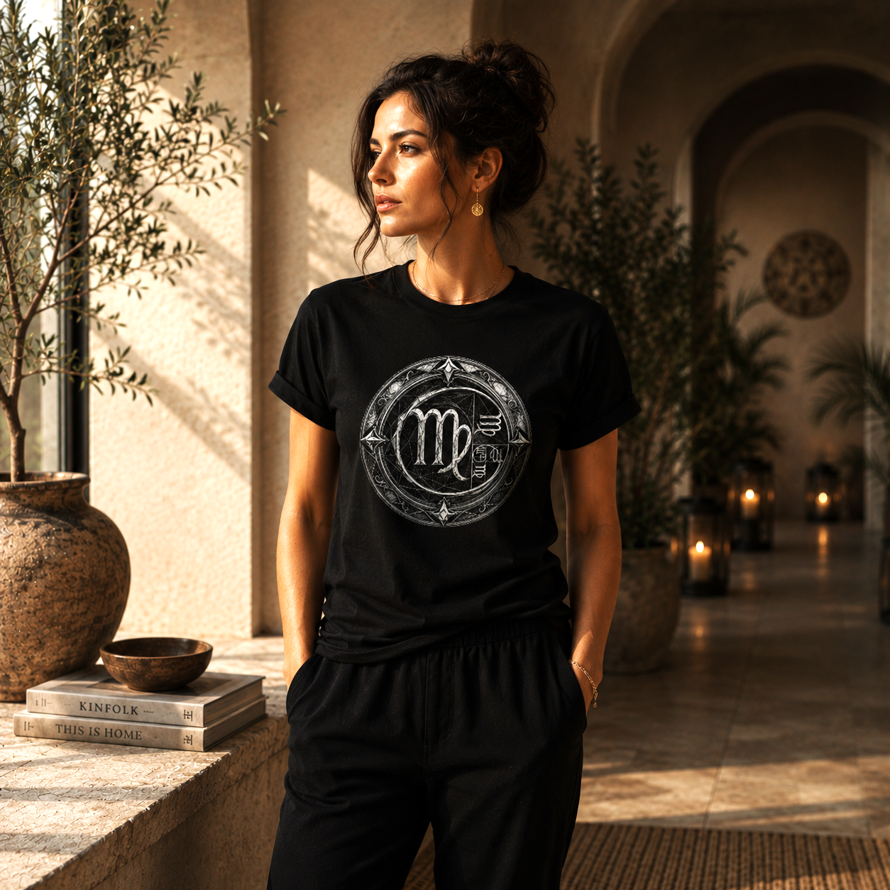 Modelo femenino con camiseta negra Virgo Áureo de Astrálisis en escenario minimalista de inspiración mediterránea