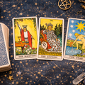 Mini lectura de tarot con cartas El Mago, La Emperatriz y La Estrella en mesa de consulta esotérica.