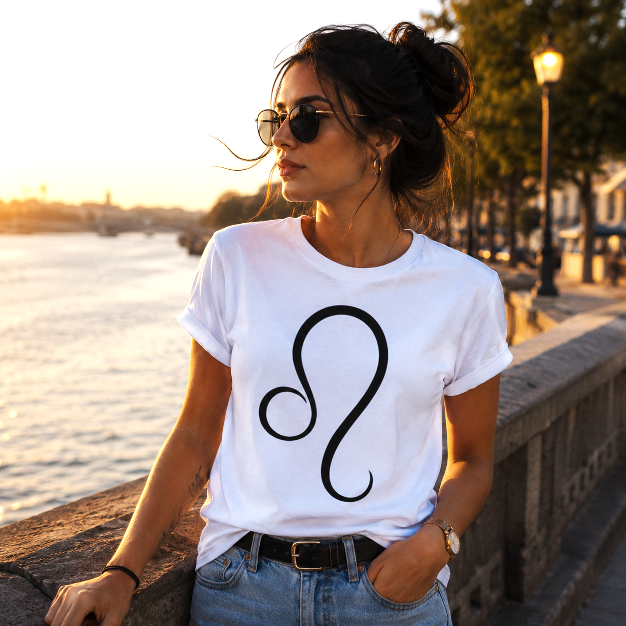 Mujer vistiendo camiseta blanca Leo con símbolo zodiacal minimalista en un entorno urbano contemporáneo